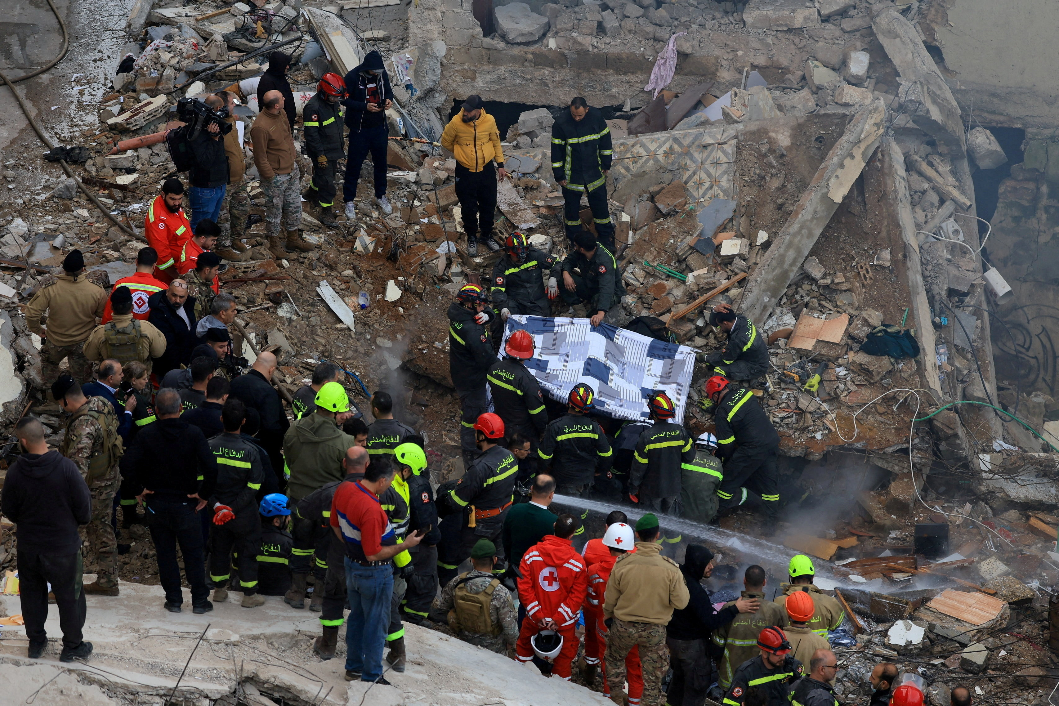 Rescue workers work at the site where a residential building collapsed in Tripoli