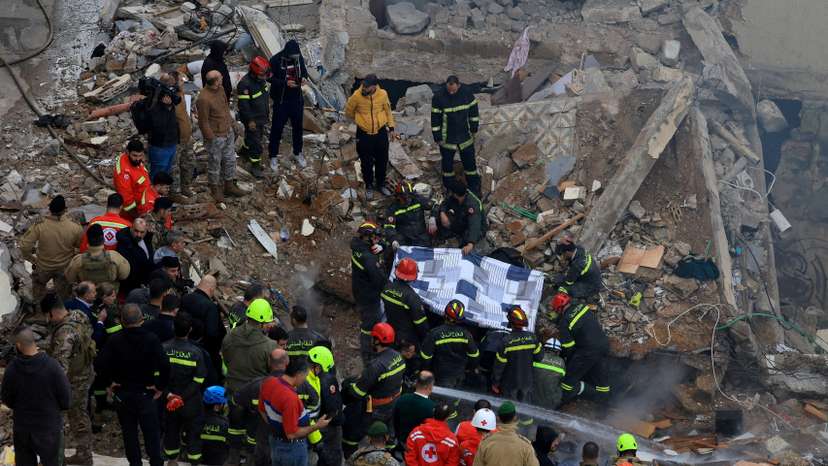 Rescue workers work at the site where a residential building collapsed in Tripoli