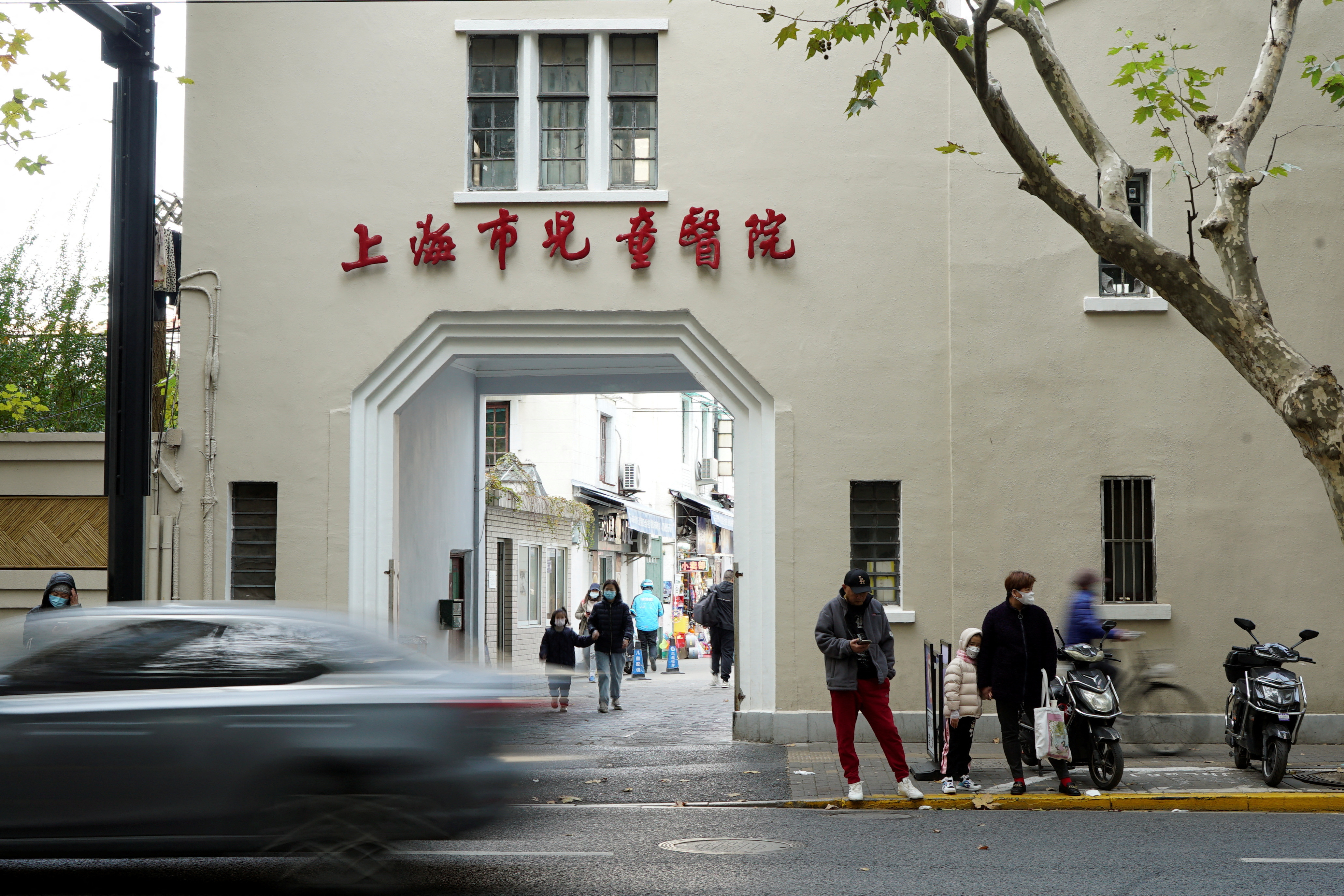 People stand outside a children's hospital in Shanghai