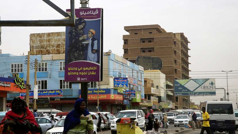 A general view shows Sudanese people and traffic along a street in Khartoum