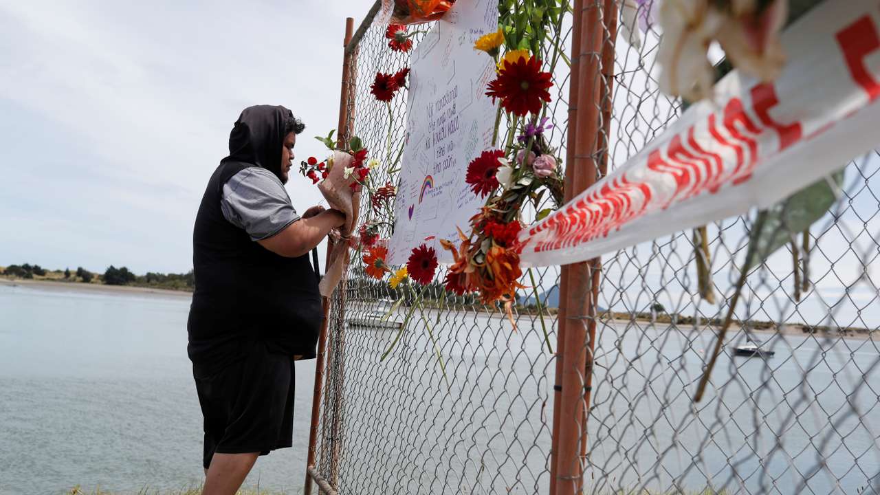 FILE PHOTO: A man offers flowers at a memorial at the harbour in Whakatane, following the White Island volcano eruption in New Zealand
