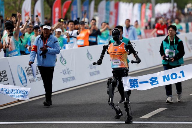 Tiangong Ultra, a humanoid robot runs across the finish line while securing the first position during the E-Town Humanoid Robot Half Marathon, in Beijing, China April 19, 2025. REUTERS/Tingshu Wang