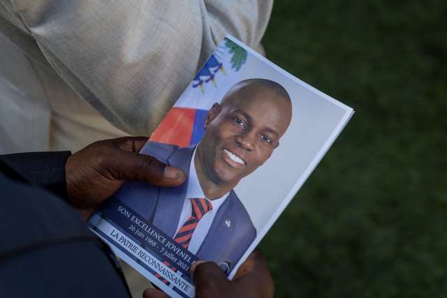 File photo: A person holds a photo of late Haitian President Jovenel Moise, who was shot dead earlier this month, during his funeral at his family home in Cap-Haitien, Haiti, July 23, 2021. REUTERS/Ricardo Arduengo/File photo