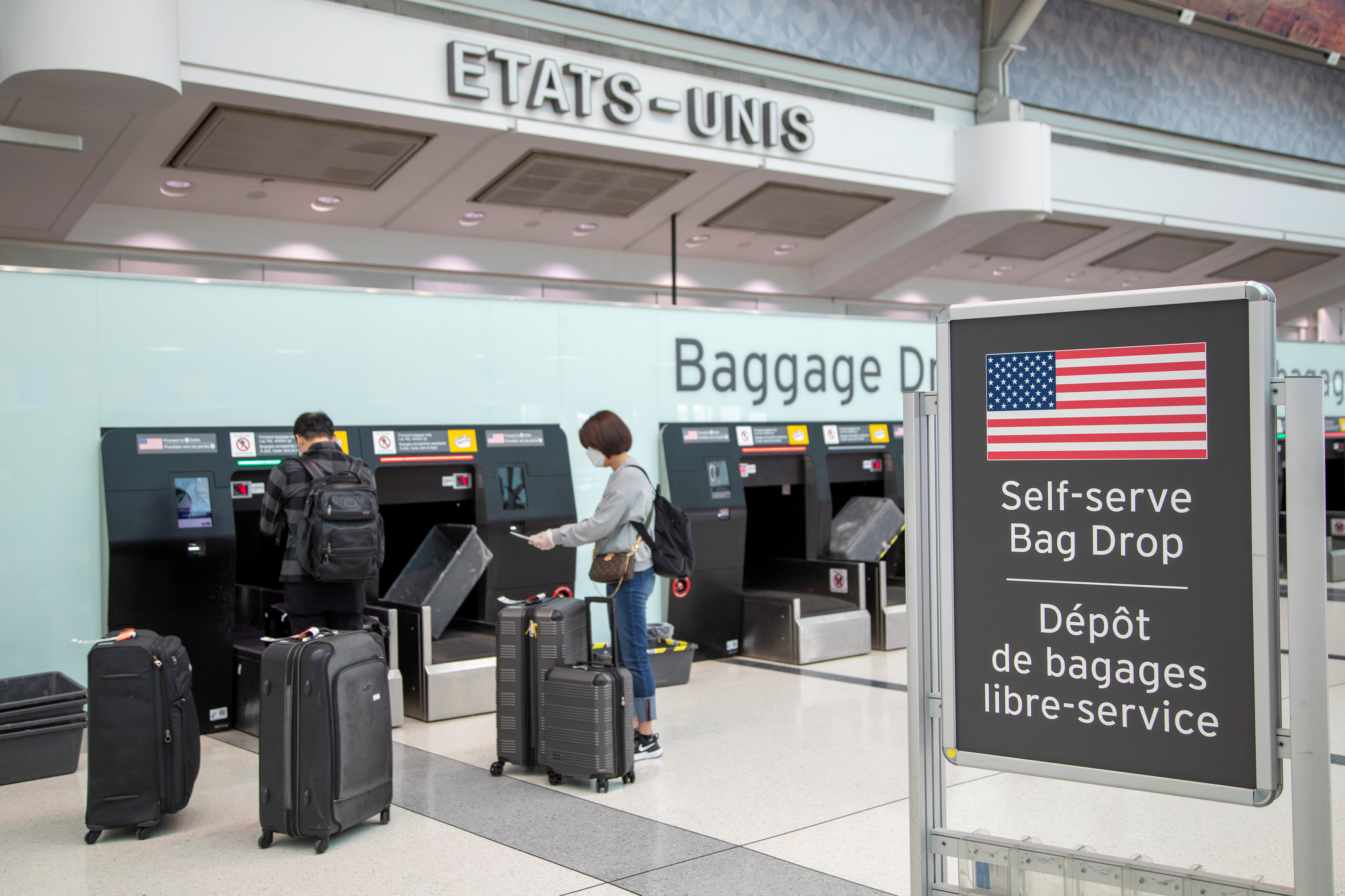 Passengers walk towards gates staffed by U.S. immigration officers in Toronto
