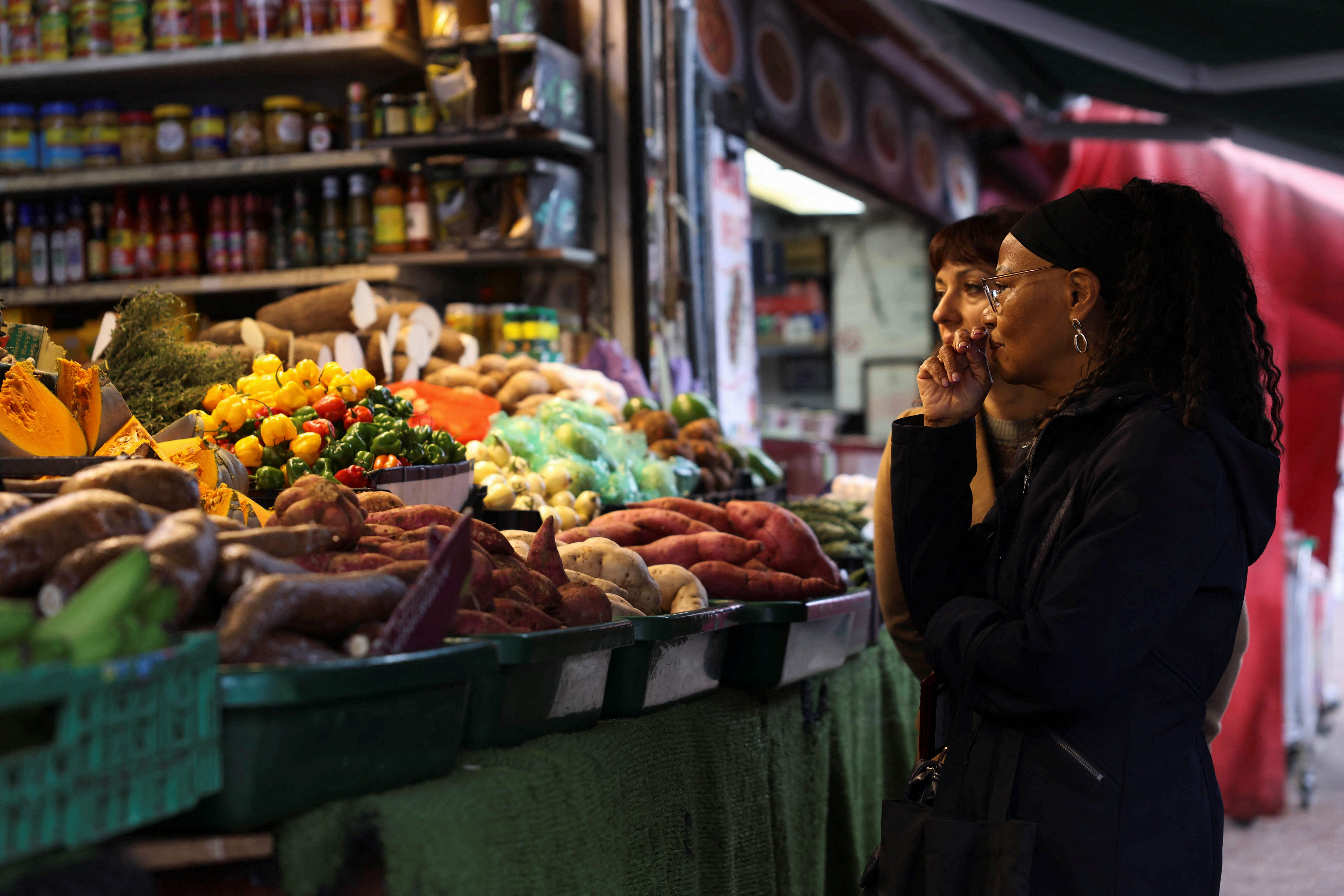 FILE PHOTO: Customer shop for produce at Ridley Road Market, ahead of Labour's budget, in London
