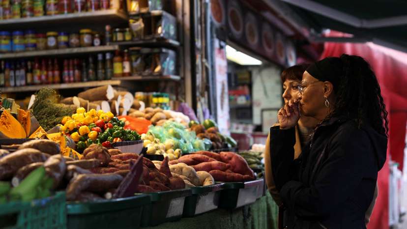 FILE PHOTO: Customer shop for produce at Ridley Road Market, ahead of Labour's budget, in London