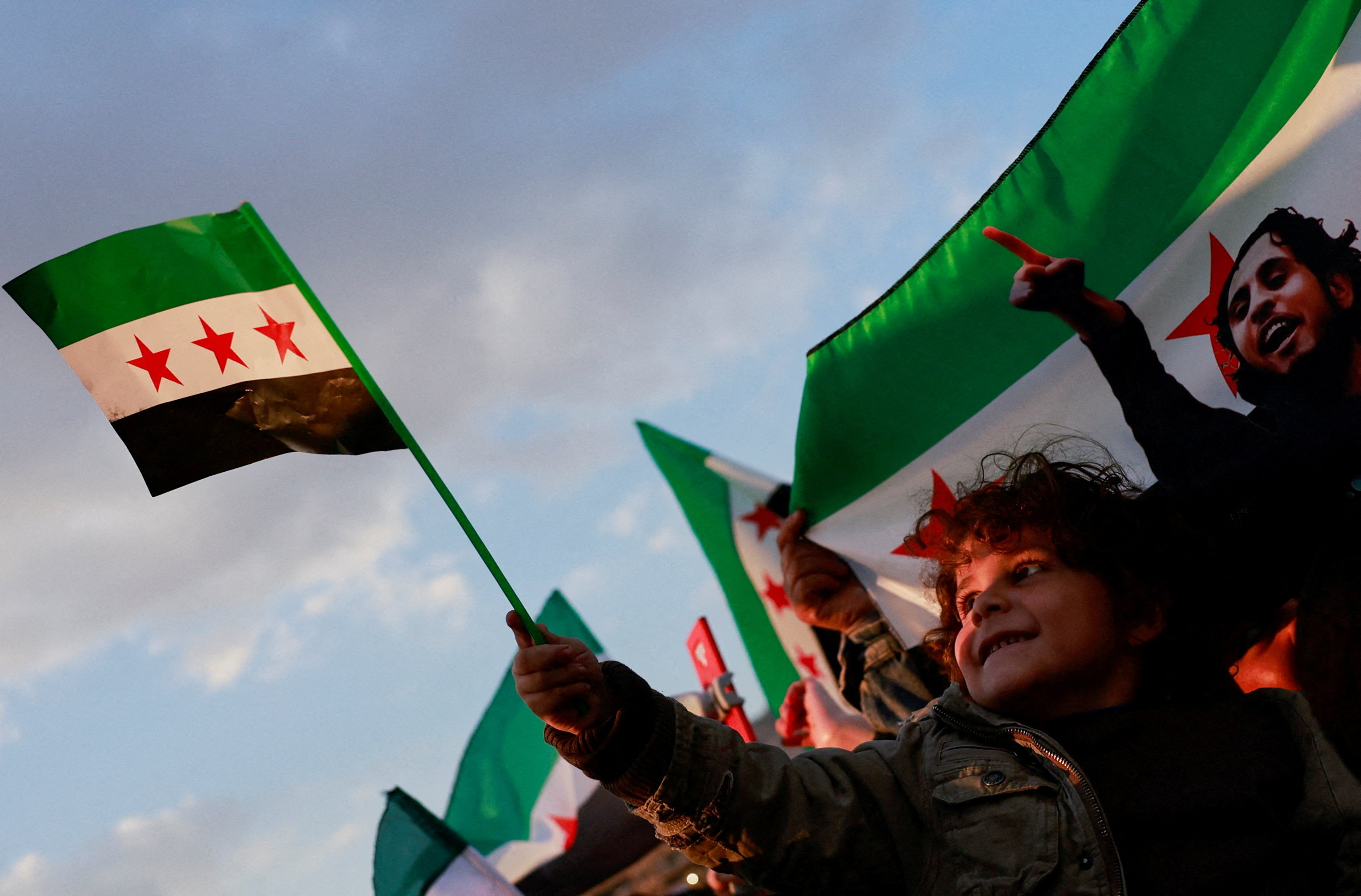 People gather during a celebration called by Hayat Tahrir al-Sham (HTS) after the ousting of Syria's Bashar al-Assad, in Damascus