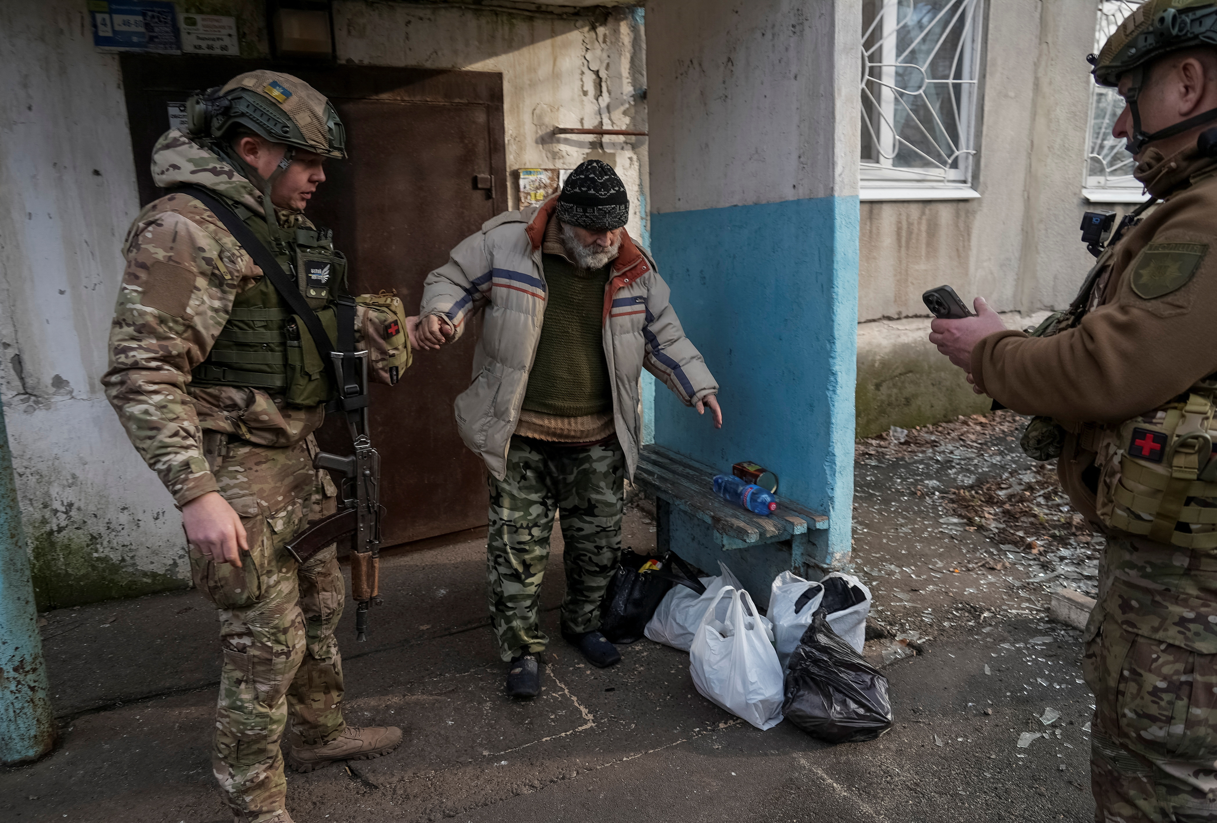 Ukrainian police officers evacuate a resident in the frontline town of Pokrovsk