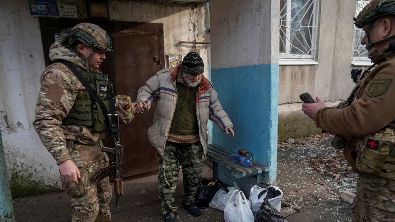 Ukrainian police officers evacuate a resident in the frontline town of Pokrovsk