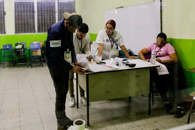 Electoral workers gather at a desk as the vote counting begins during the general election in Tegucigalpa, Honduras, November 30, 2025. REUTERS/Leonel
