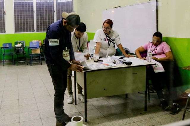 Electoral workers gather at a desk as the vote counting begins during the general election in Tegucigalpa, Honduras, November 30, 2025. REUTERS/Leonel