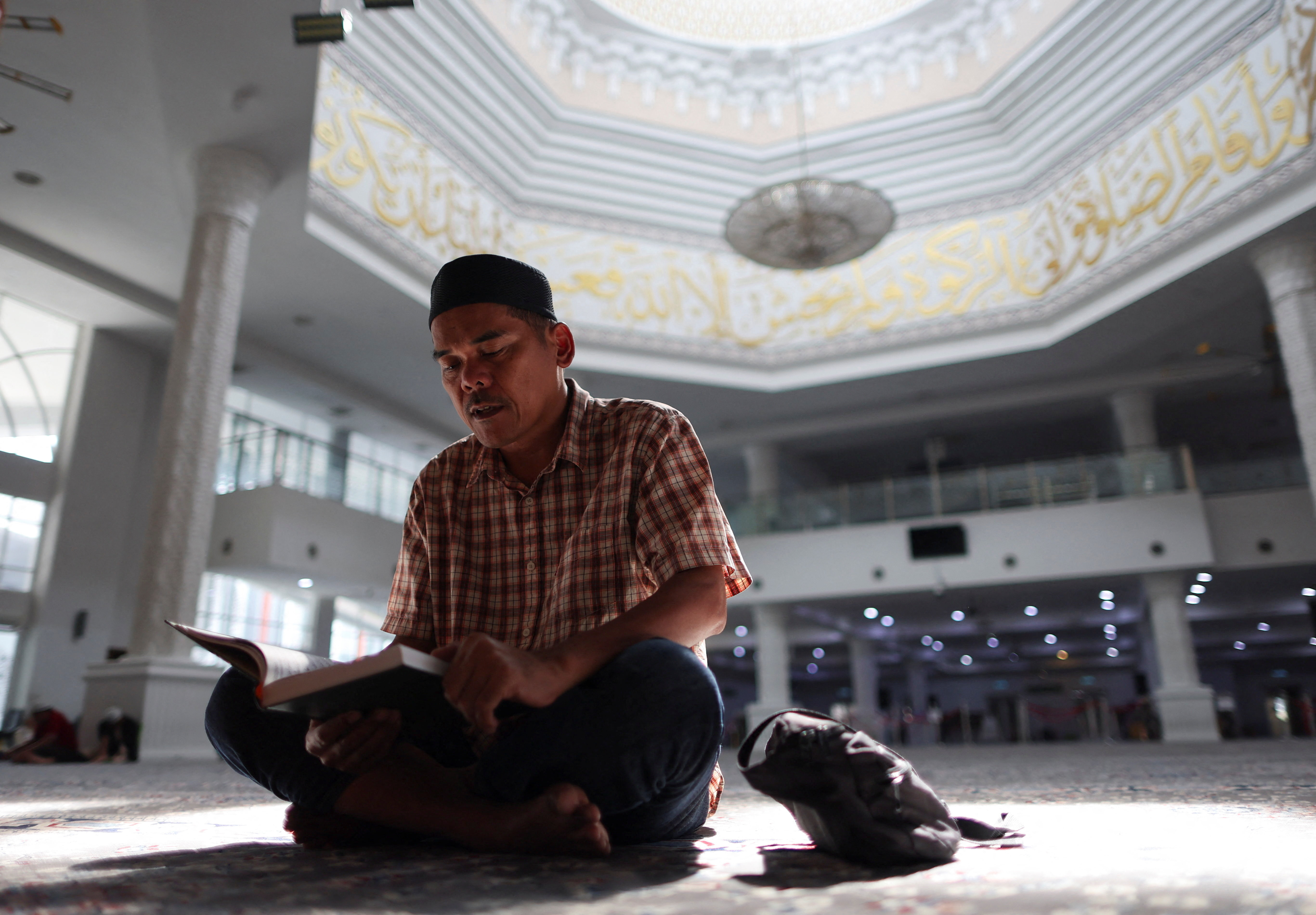 A Muslim man recites the Koran during Ramadan in Kuala Lumpur
