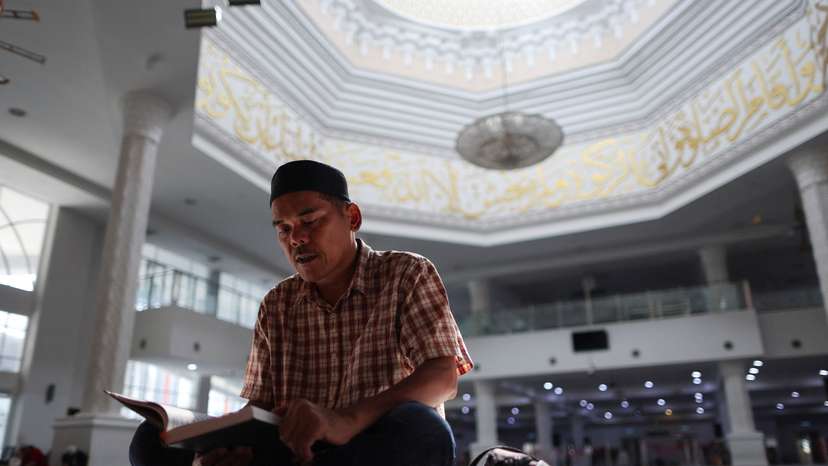 A Muslim man recites the Koran during Ramadan in Kuala Lumpur