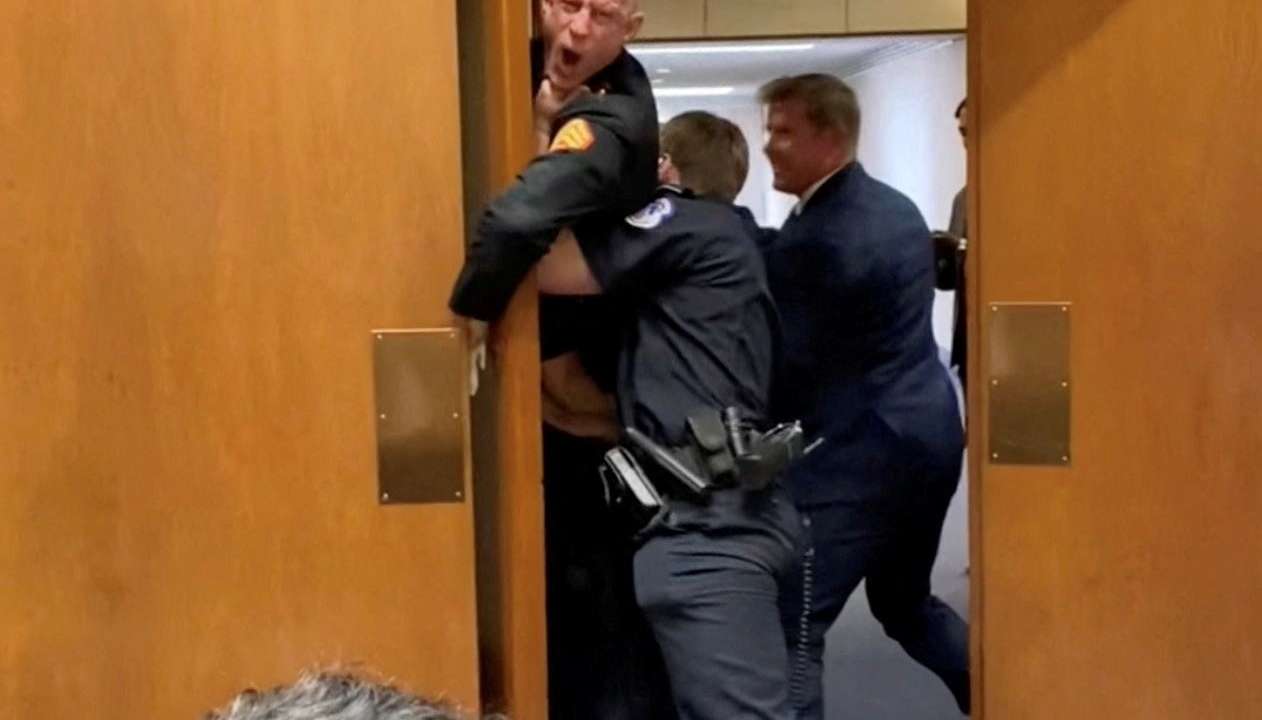 Former Marine Brian McGinnis is dragged out during the Senate Armed Services subcommittee hearing, in Washington