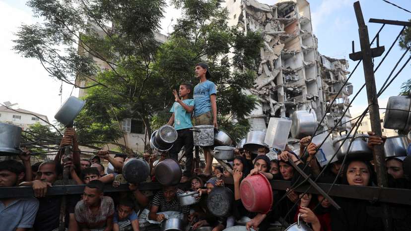 Palestinians wait to receive food from a charity kitchen, amid a hunger crisis, in Gaza City