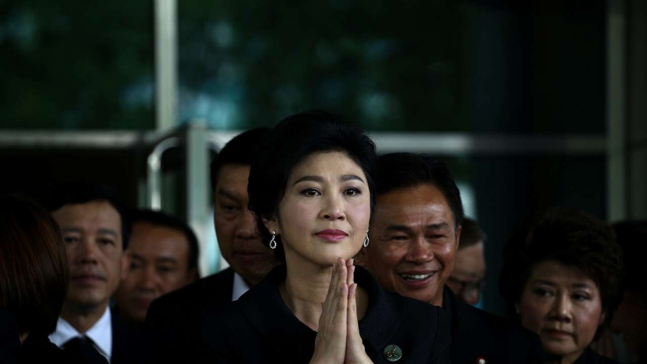 Ousted former Thai prime minister Yingluck Shinawatra greets supporters as she arrives at the Supreme Court in Bangkok