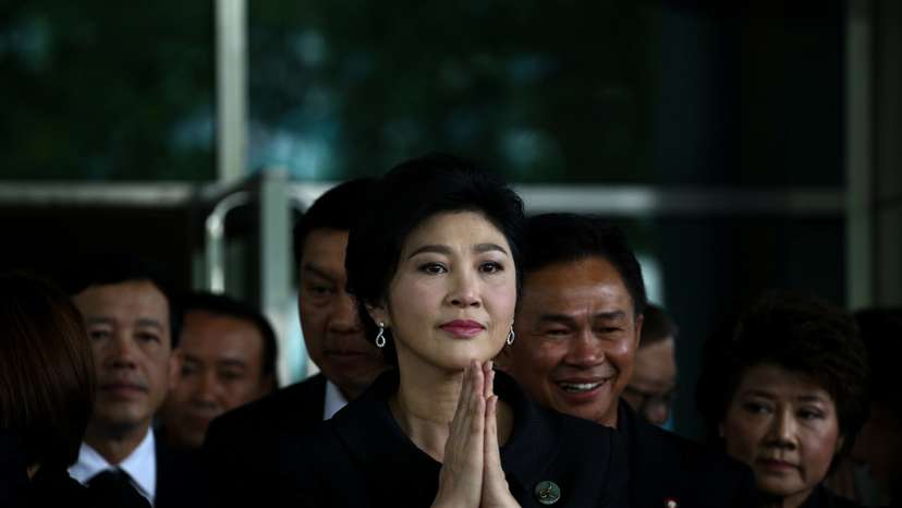 Ousted former Thai prime minister Yingluck Shinawatra greets supporters as she arrives at the Supreme Court in Bangkok