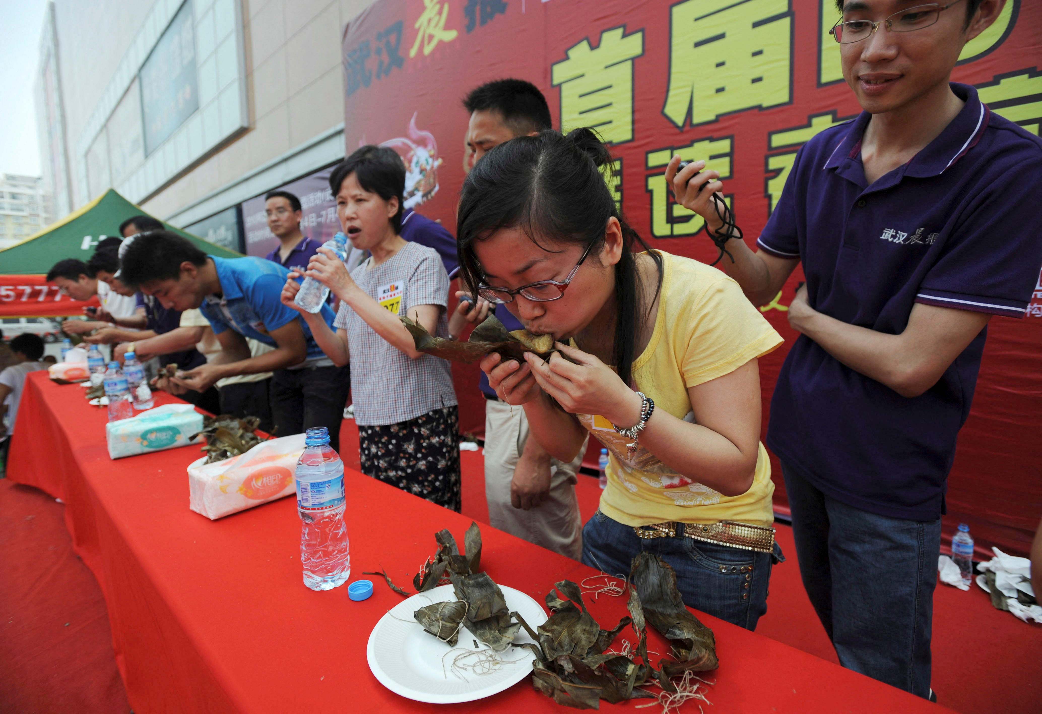 FILE PHOTO: Participants compete in a zongzi-eating competition held at a shopping mall in Wuhan