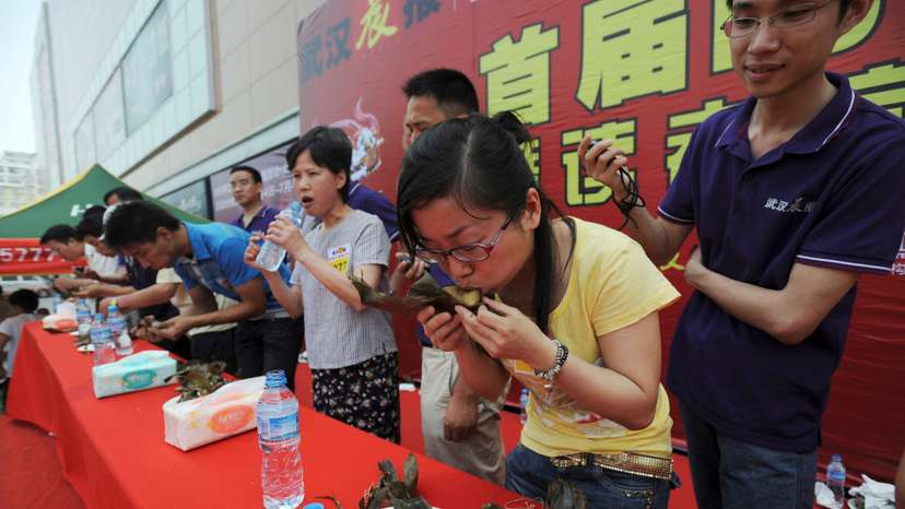 FILE PHOTO: Participants compete in a zongzi-eating competition held at a shopping mall in Wuhan