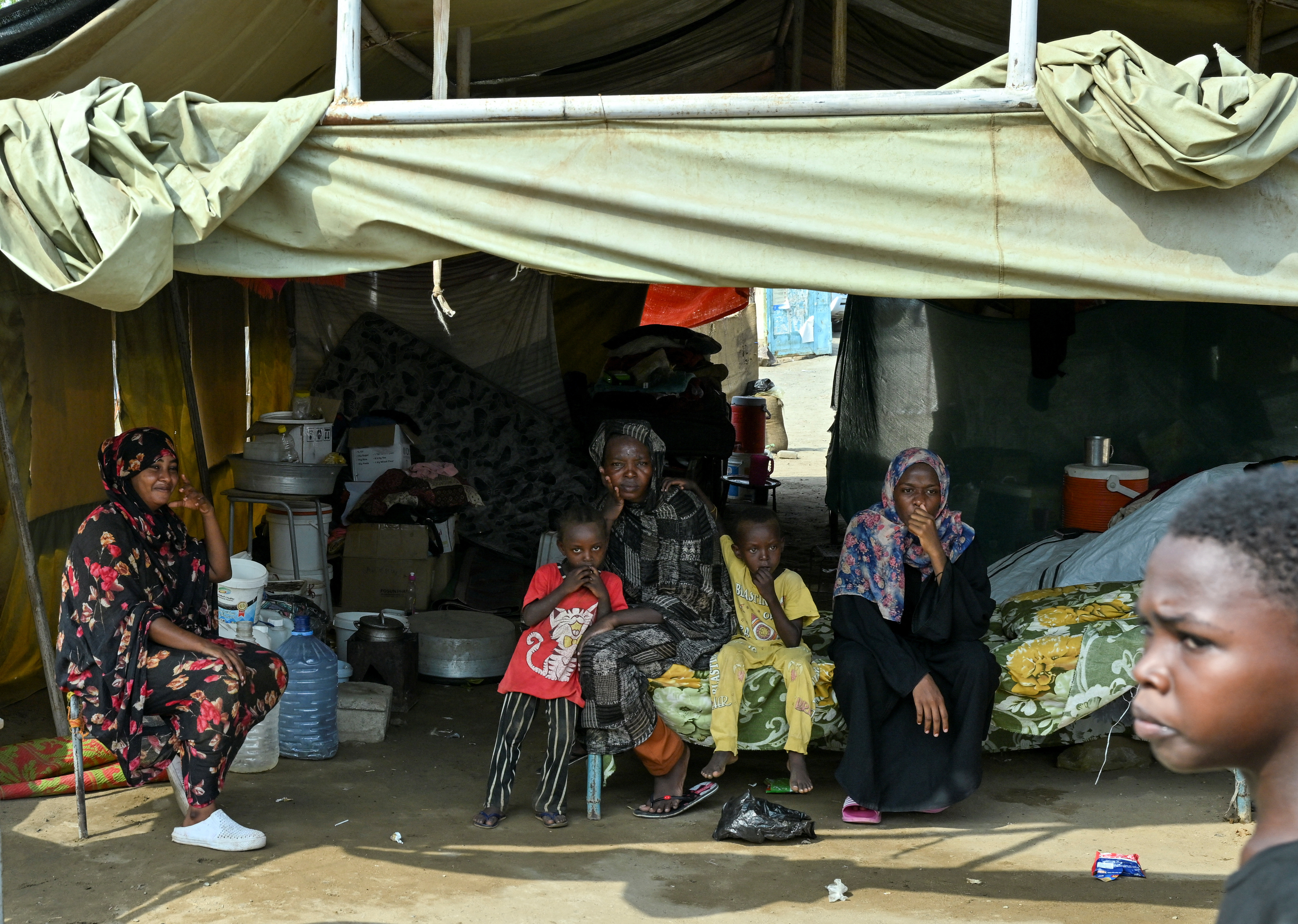 Displaced people sit inside a tent at a school turned into a shelter, in Port Sudan