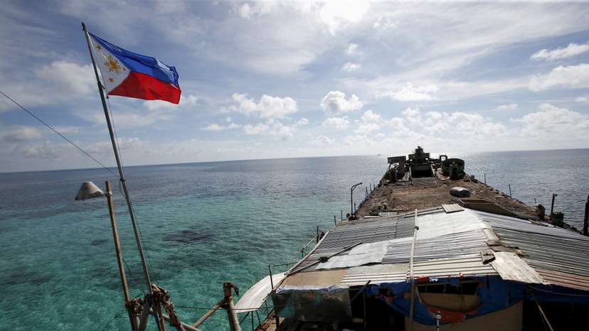FILE PHOTO: A Philippine flag flutters from BRP Sierra Madre, a dilapidated Philippine Navy ship that has been aground since 1999 and became a Philippine military detachment on the disputed Second Thomas Shoal