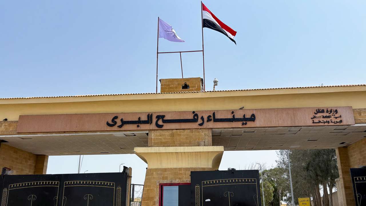 People stand at the Rafah border crossing between Egypt and the Gaza Strip, in Rafah