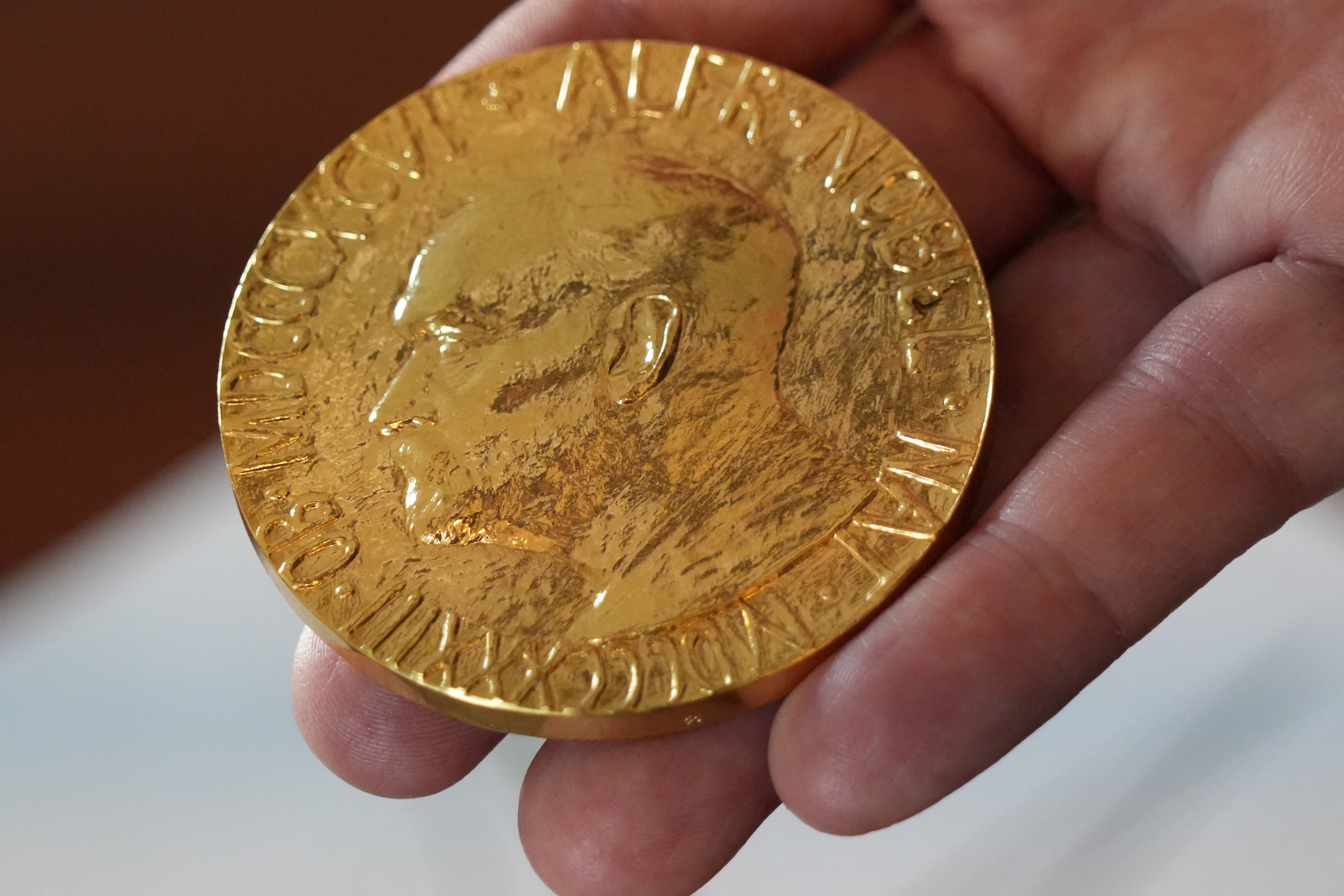 An employee of the Norwegian Nobel Institute holds a replica of a Nobel Peace Medal in the Institute in Oslo