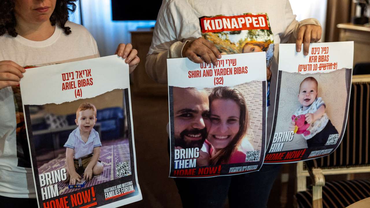 FILE PHOTO: Bibas Levy holds with her friend Ulus pictures of her brother Yarden who was kidnapped with his wife and 2 children in Geneva