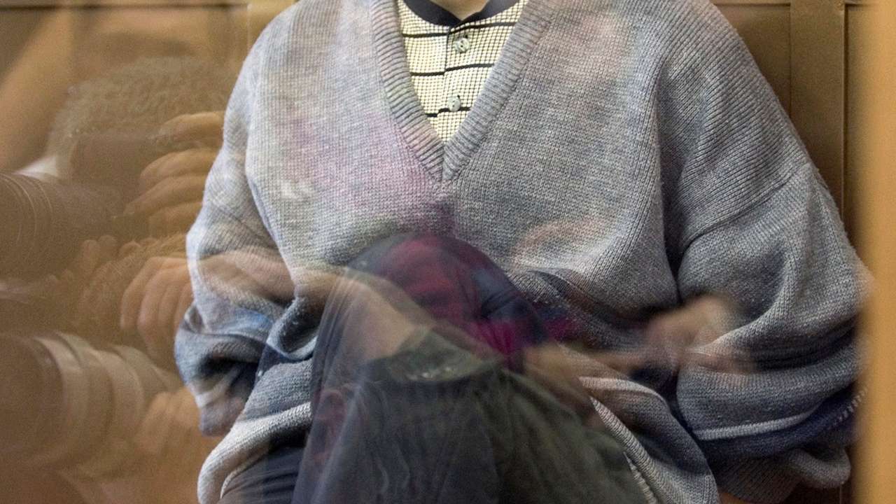 FILE PHOTO: Alexander Pichushkin sits behind the glass in a Moscow court
