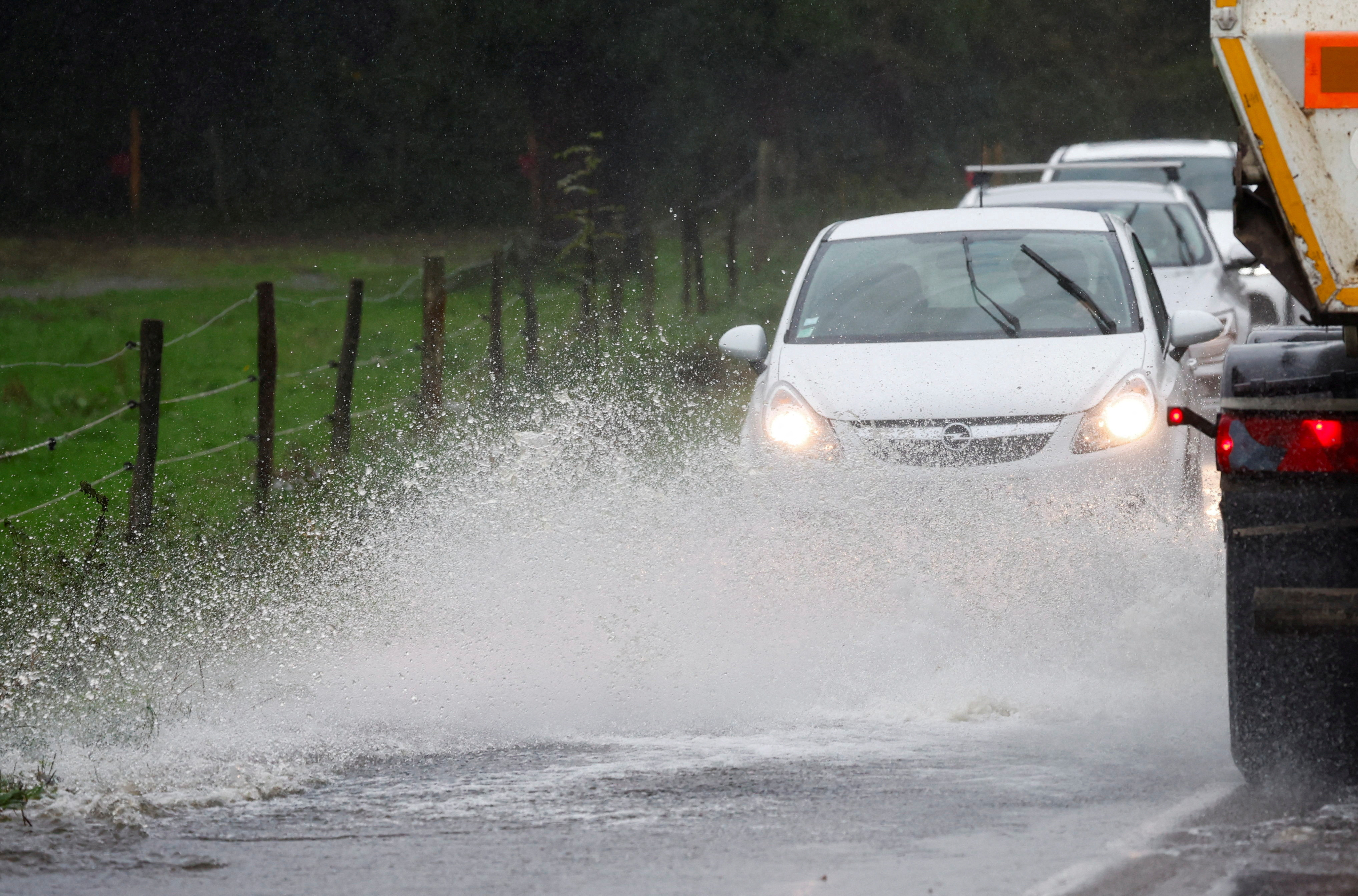 FILE PHOTO: Vehicles drive along a flooded road as heavy rains continues in Vertou