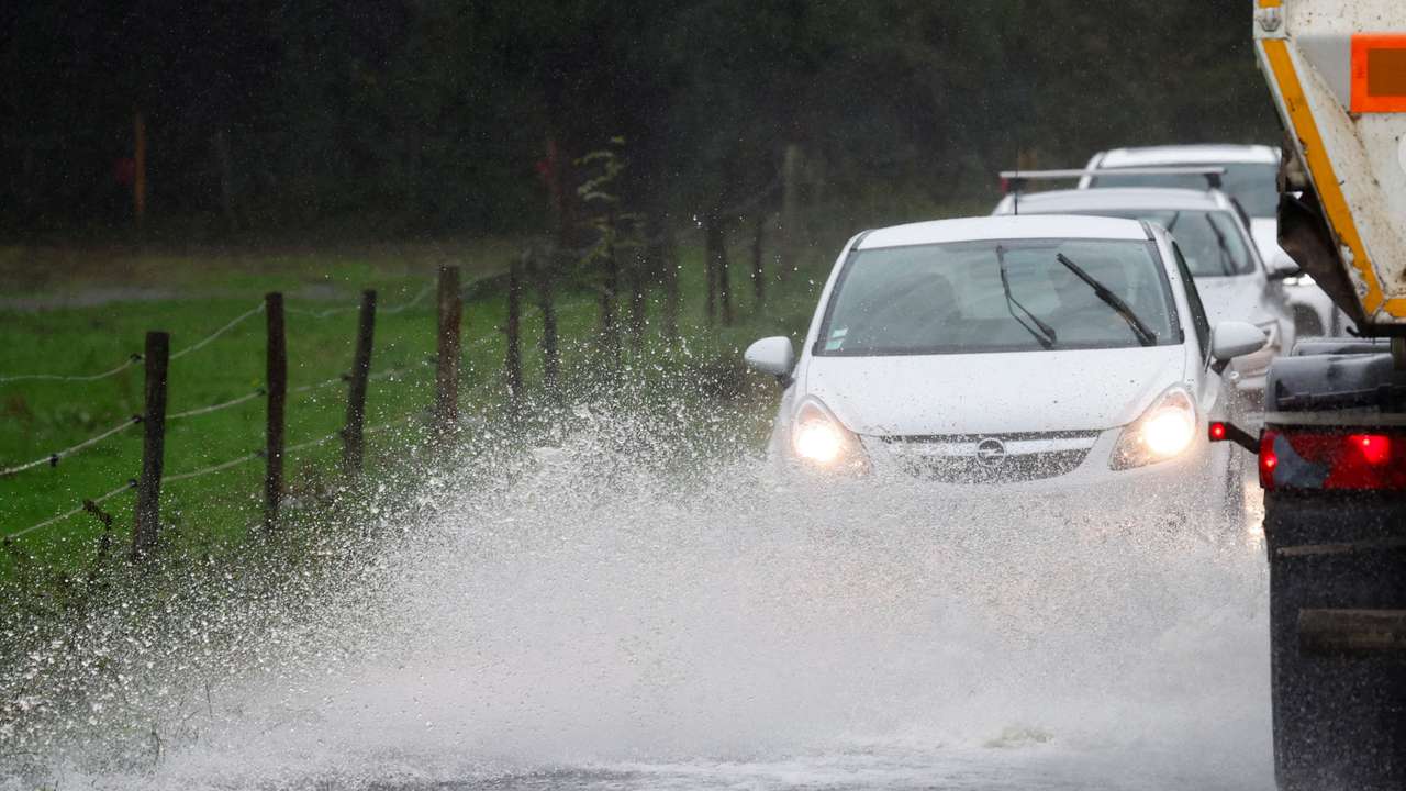 FILE PHOTO: Vehicles drive along a flooded road as heavy rains continues in Vertou