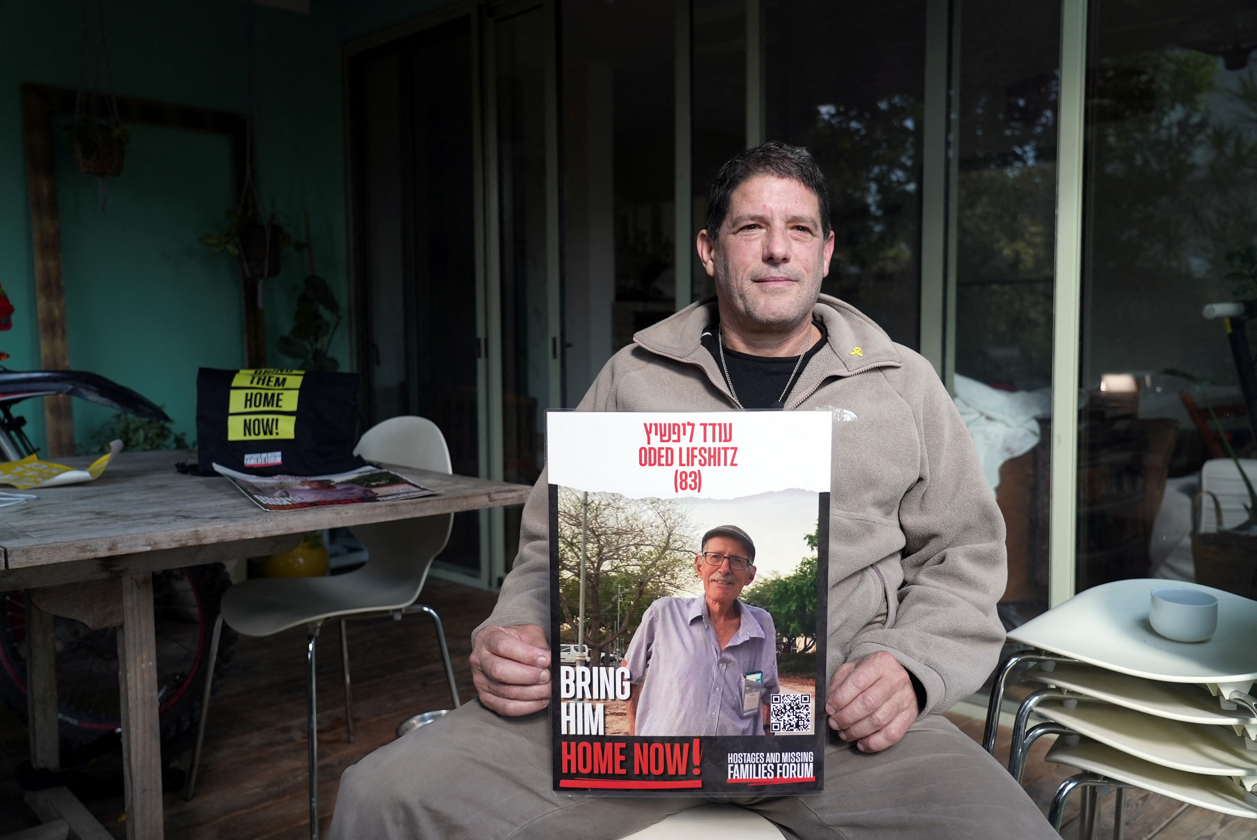 Yzhar Lifshitz, a resident of Kibbutz Nir Oz, holds a poster of his father, Oded Lifshitz, 84, who has been held hostage in Gaza since the deadly October 7, 2023 attack by Hamas, during an interview with Reuters in Karmei Yosef