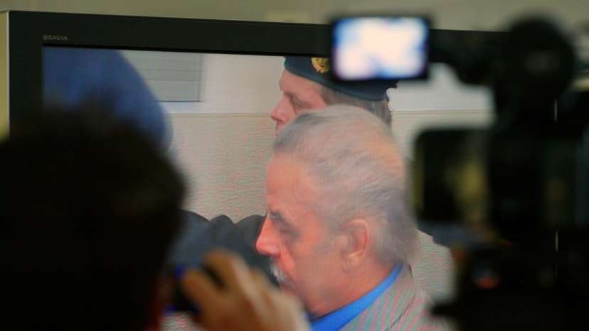 Journalists watch TV screen inside media tent as 73-year-old Austrian Fritzl appears in court on fourth day of his trial in St. Poelten