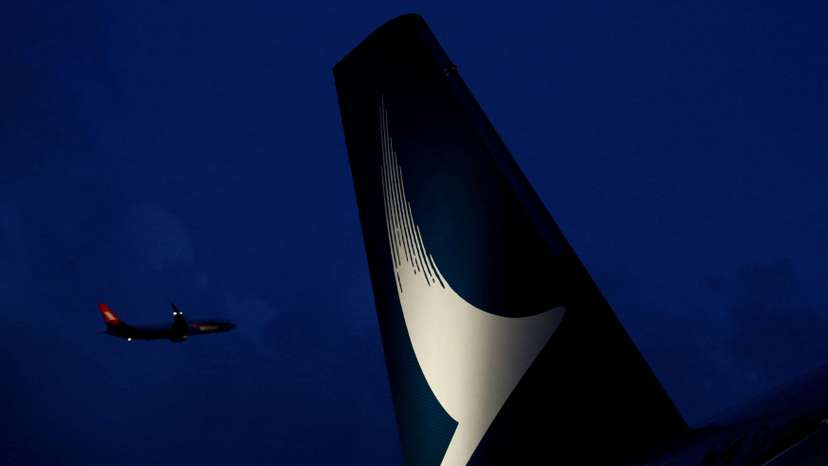 FILE PHOTO: A plane flies behind a new Cathay Pacific Airways Airbus A350 after being received by the airline at Hong Kong