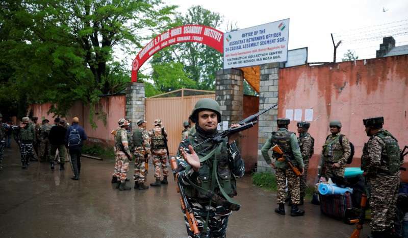 Security personnel stand guard outisde a distribution centre ahead of the fourth phase of the general elections in Srinagar