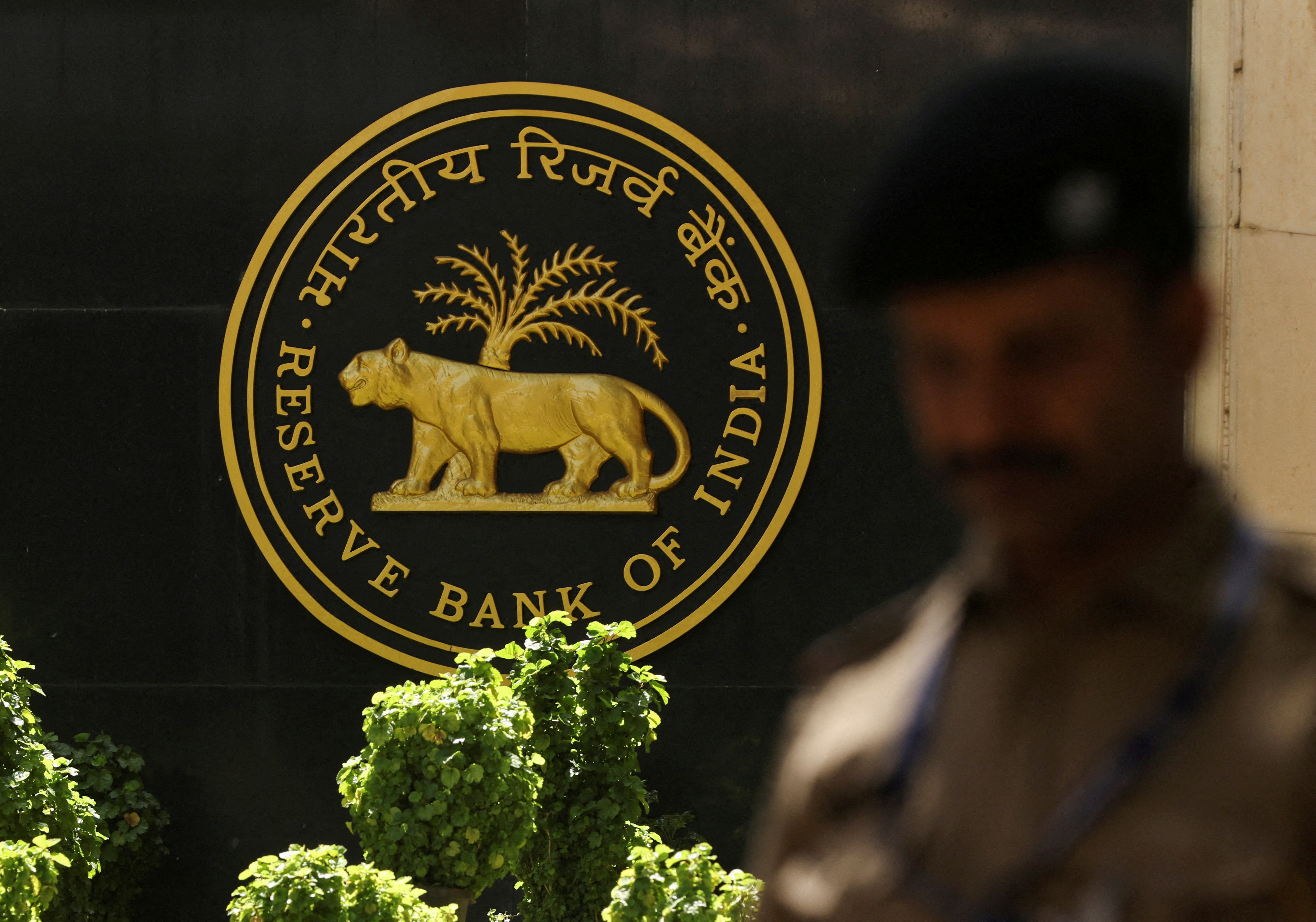 FILE PHOTO: FILE PHOTO: A police officer walks past the Reserve Bank of India (RBI) logo inside its headquarters in Mumbai