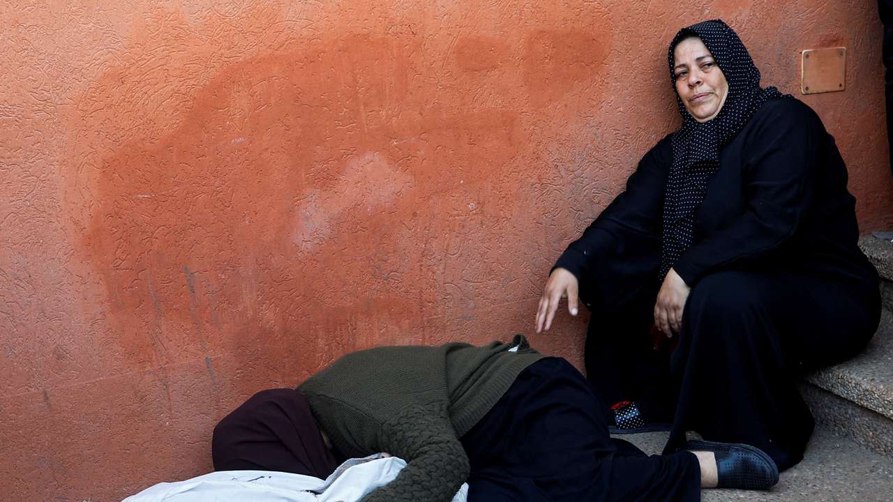 People mourn next to the bodies of Palestinians killed in Israeli strikes, during a funeral at Nasser hospital in Khan Younis