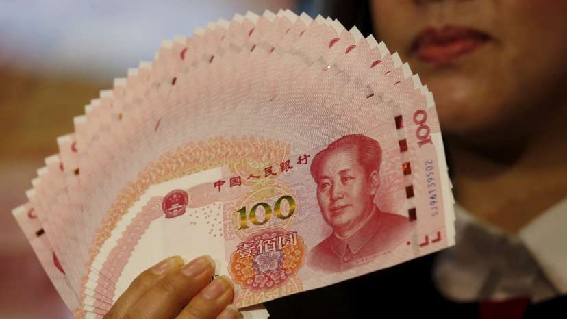 FILE PHOTO: A staffer poses with 2015 edition of the 100 renminbi notes at the Bank of China Tower in Hong Kong