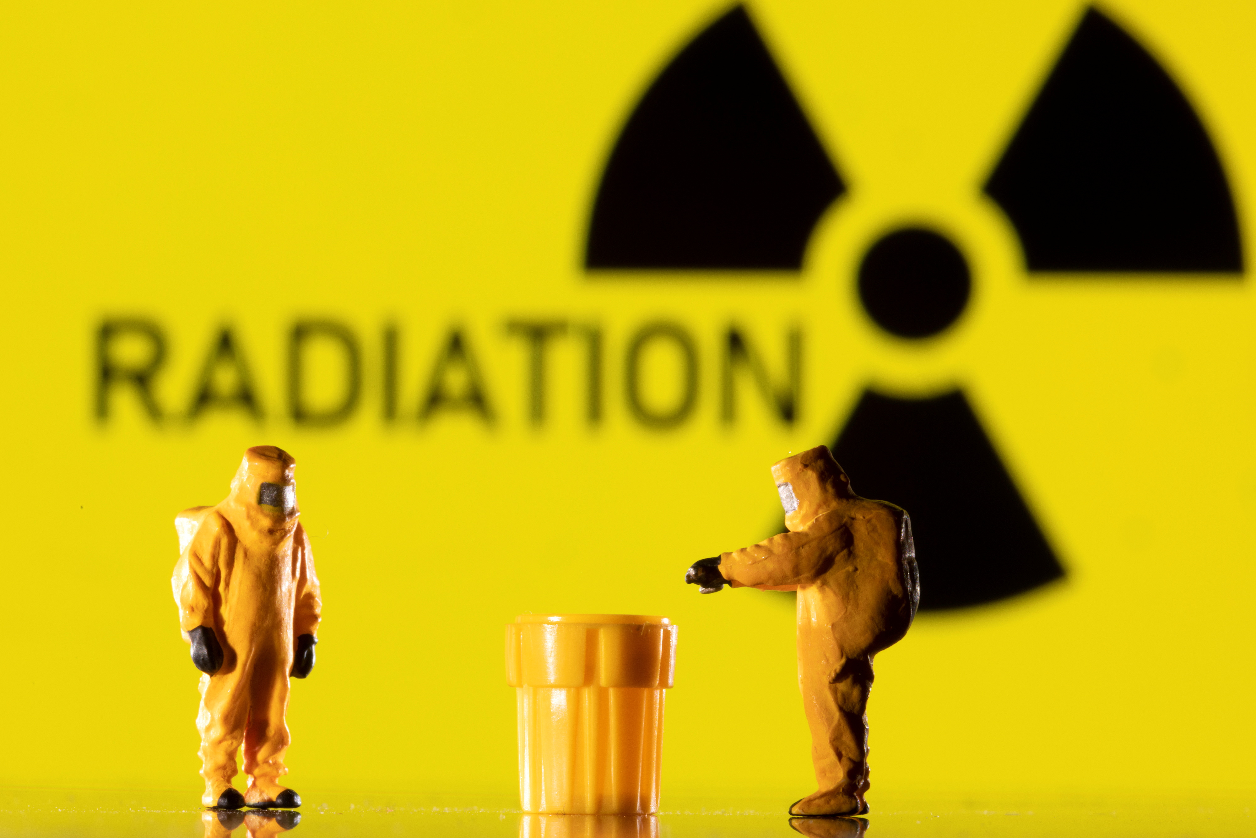 Illustration shows figurines in protective equipments and a Radiation sign