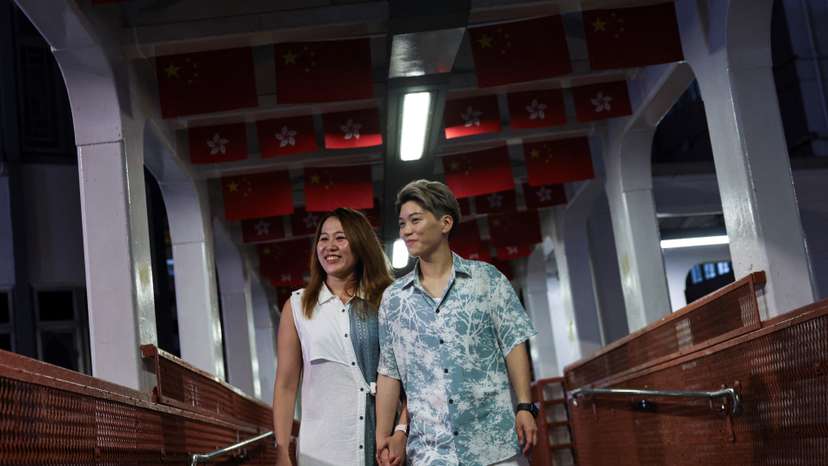 Gloria Tsang, a speech therapist, and her wife Jaedyn Yu, a drum school owner, walk on a pedestrian overpass in Hong Kong