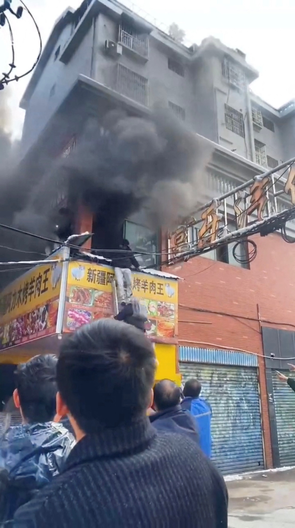 Thick plumes of smoke emerge from a building after a street shop caught fire in Xinyu City of Jiangxi Province