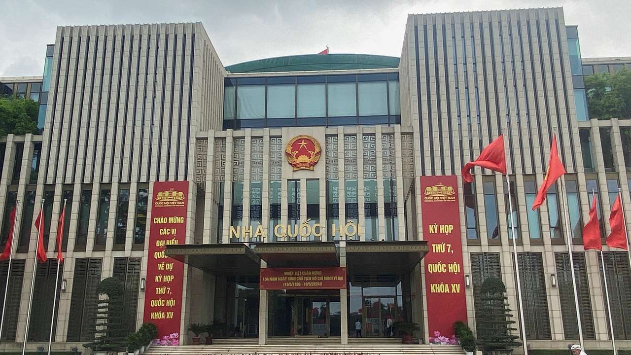 A man cycles in front of the National Assembly Building of Vietnam, in Hanoi