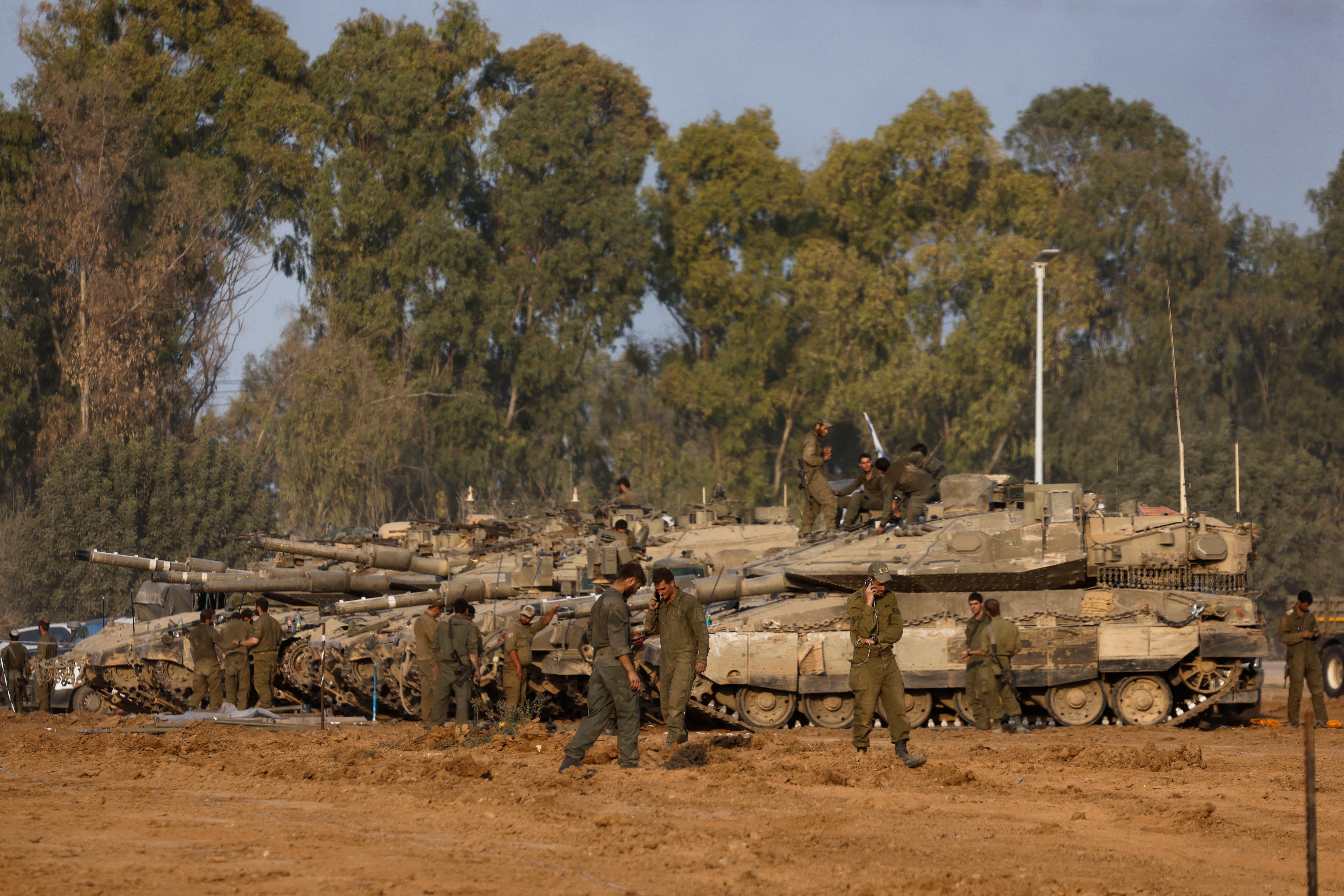 Israeli soldiers stand by tanks, after returning from Gaza, near the Israel-Gaza border, in Israel
