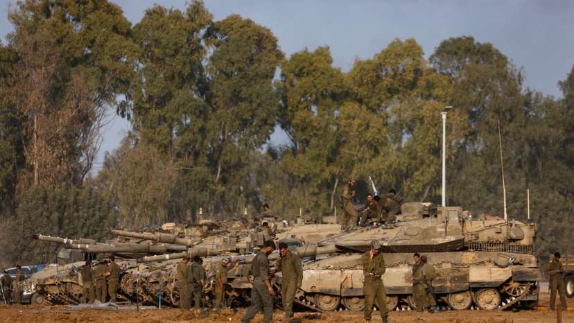 Israeli soldiers stand by tanks, after returning from Gaza, near the Israel-Gaza border, in Israel