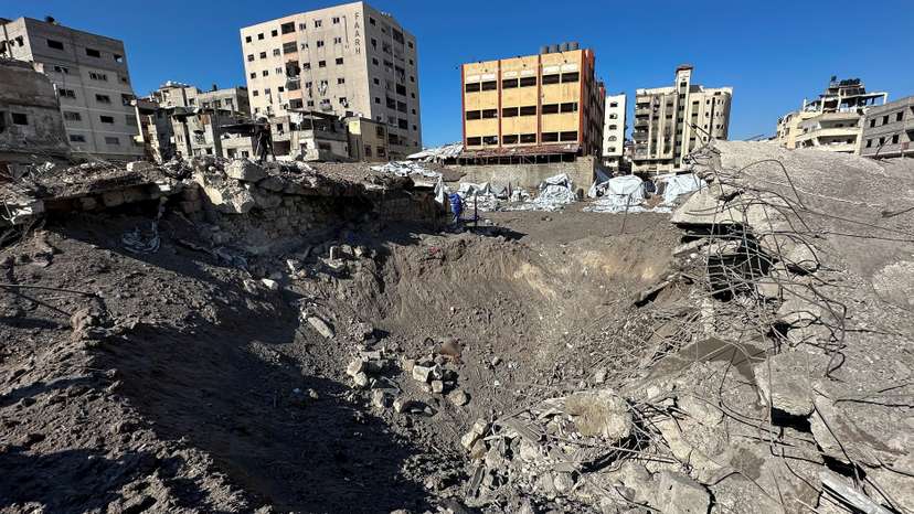 Palestinians inspect the site of an Israeli air strike, in Gaza City