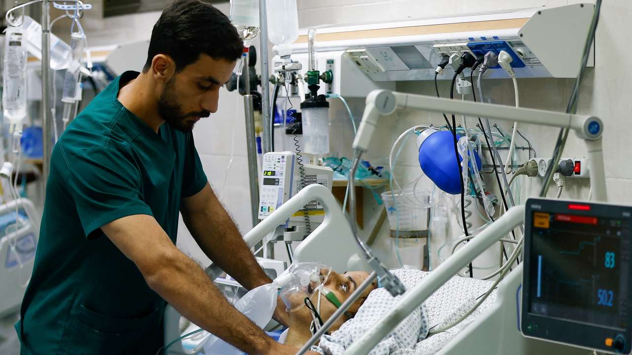 A medical worker assists a Palestinian, who was wounded in Israeli strikes, at the Intensive Care Unit (ICU) of Nasser hospital