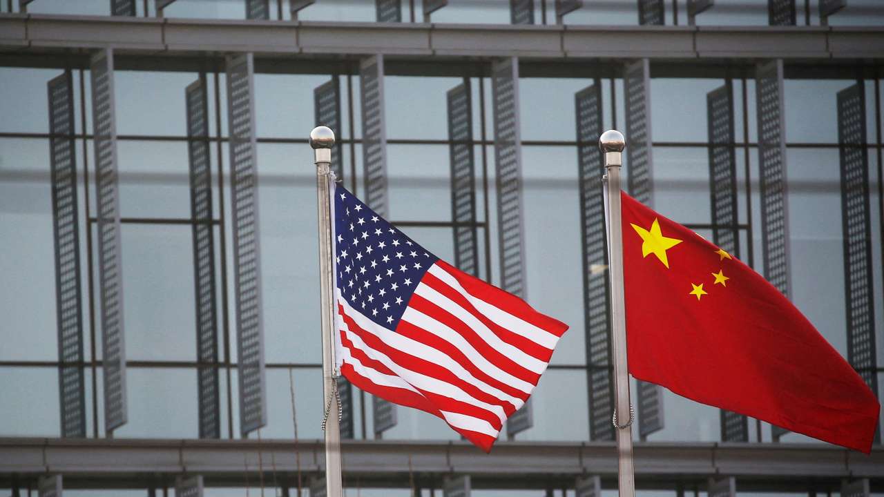 FILE PHOTO: Chinese and U.S. flags flutter outside the building of an American company in Beijing