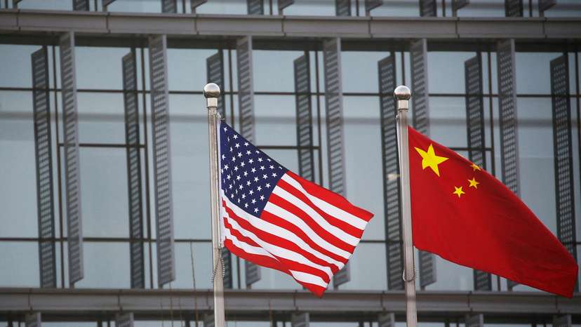 FILE PHOTO: Chinese and U.S. flags flutter outside the building of an American company in Beijing