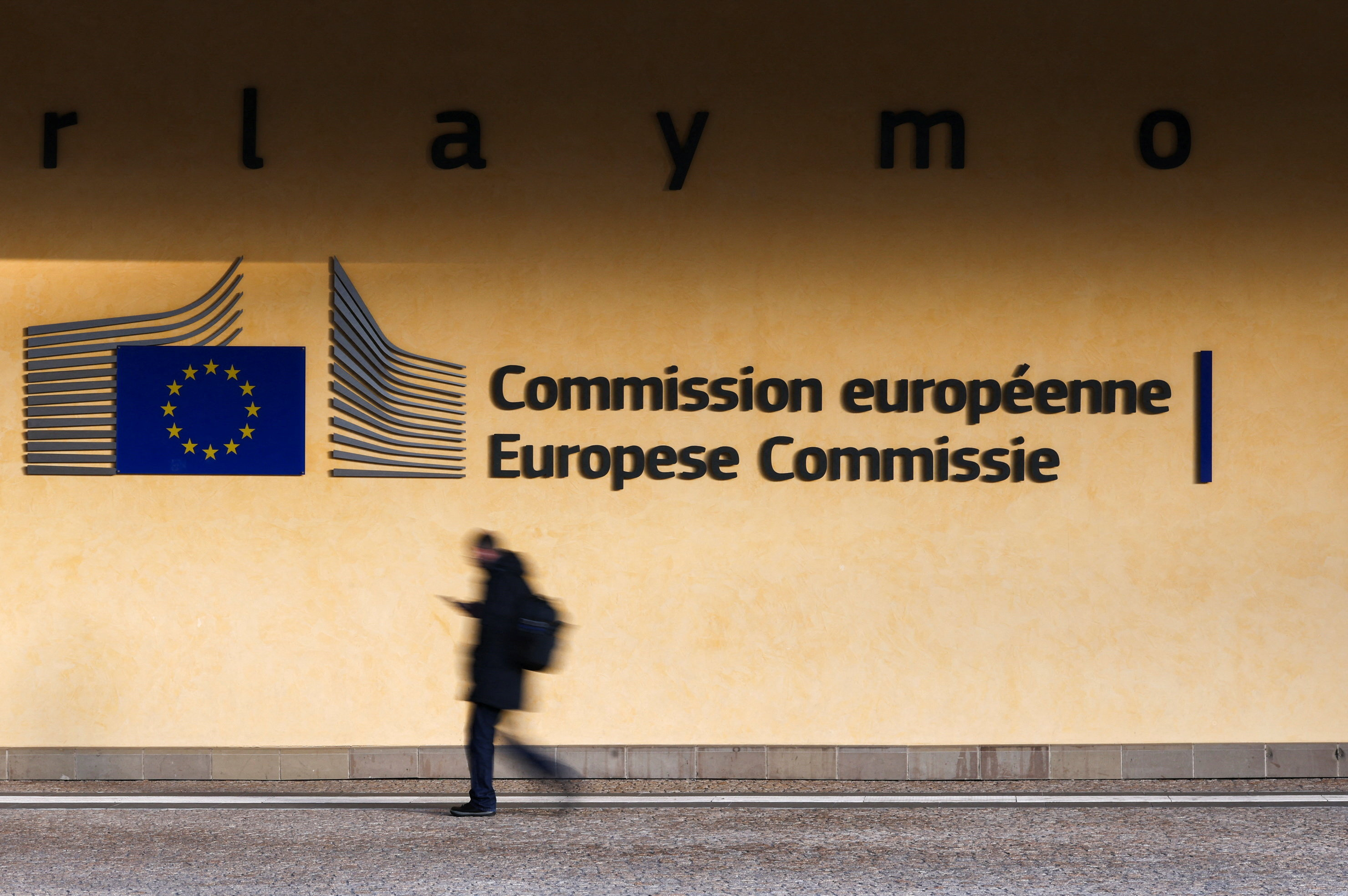 A person walks past the entrance of the European Commission headquarters in Brussels