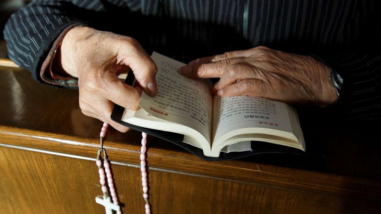 FILE PHOTO: A believer reads the bible during mass at St. Joseph's Church, a government-sanctioned Catholic church, in Beijing, China, October 1, 2018. REUTERS/Thomas Peter/File Photo